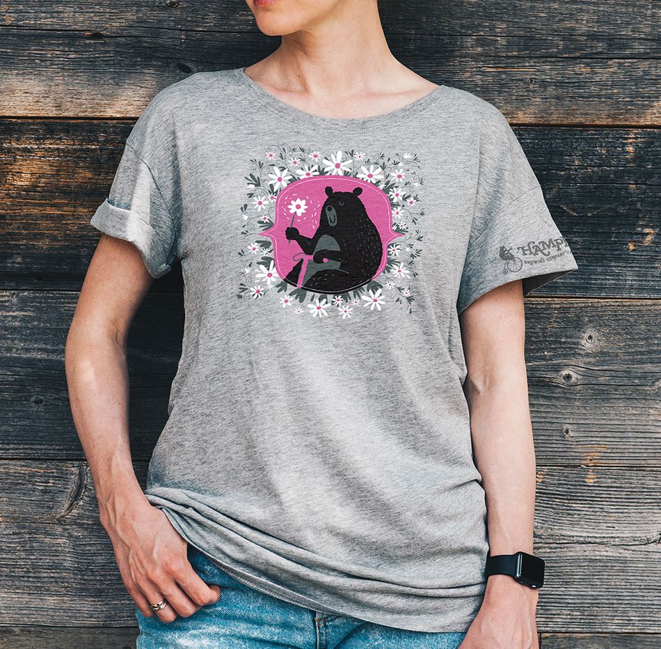 Woman wearing a grey t-shirt with a Hampline Brewing Co. bear amidst flowers design.