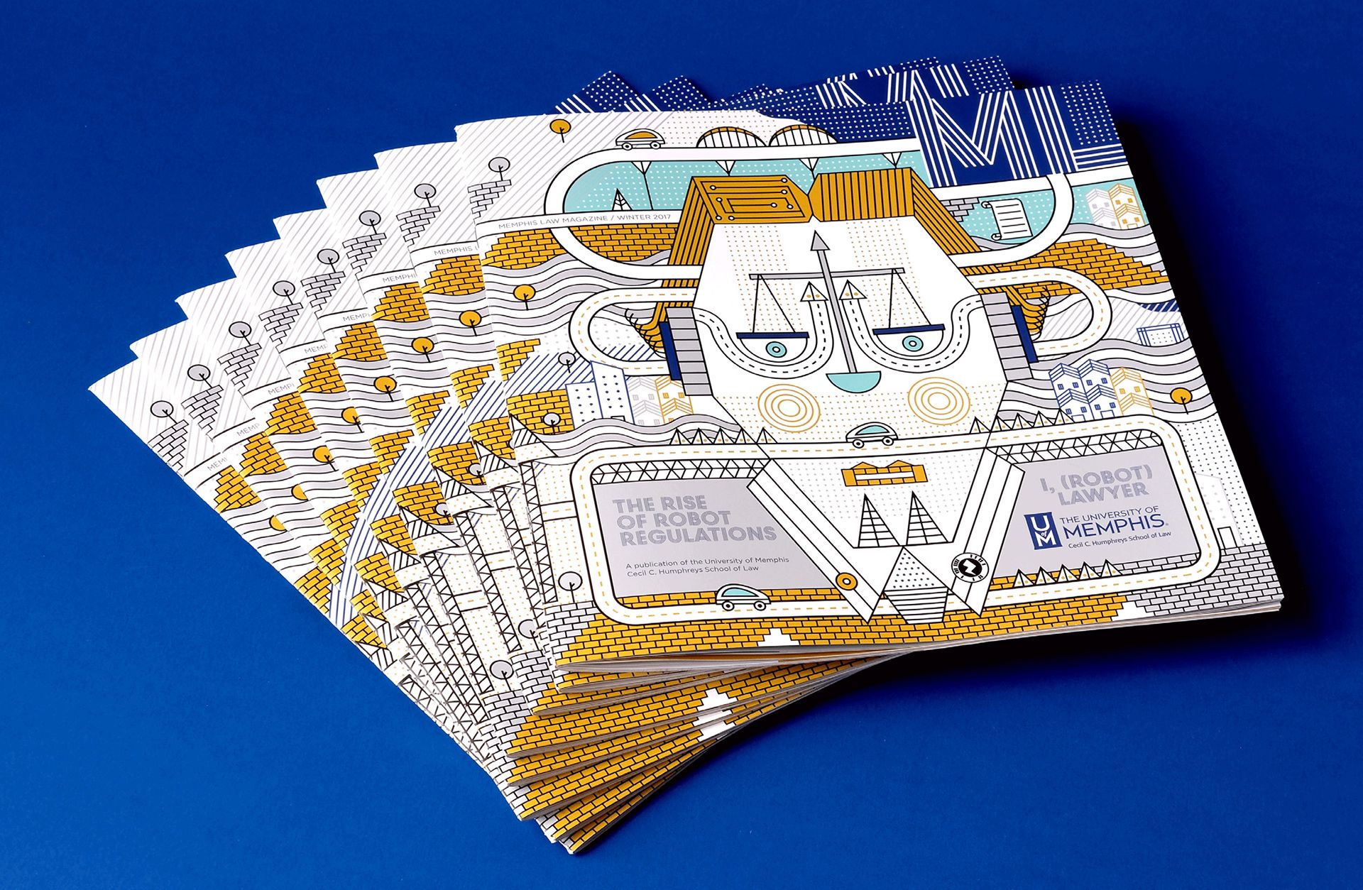 Multiple copies of Memphis Law Magazine Winter 2017 fanned out on a blue background. Cover shows a stylized robot face with scales of justice as eyes, surrounded by circuit-like roads, cars, and abstract city buildings. Text includes I, (ROBOT) LAWYER and THE RISE OF ROBOT REGULATIONS.