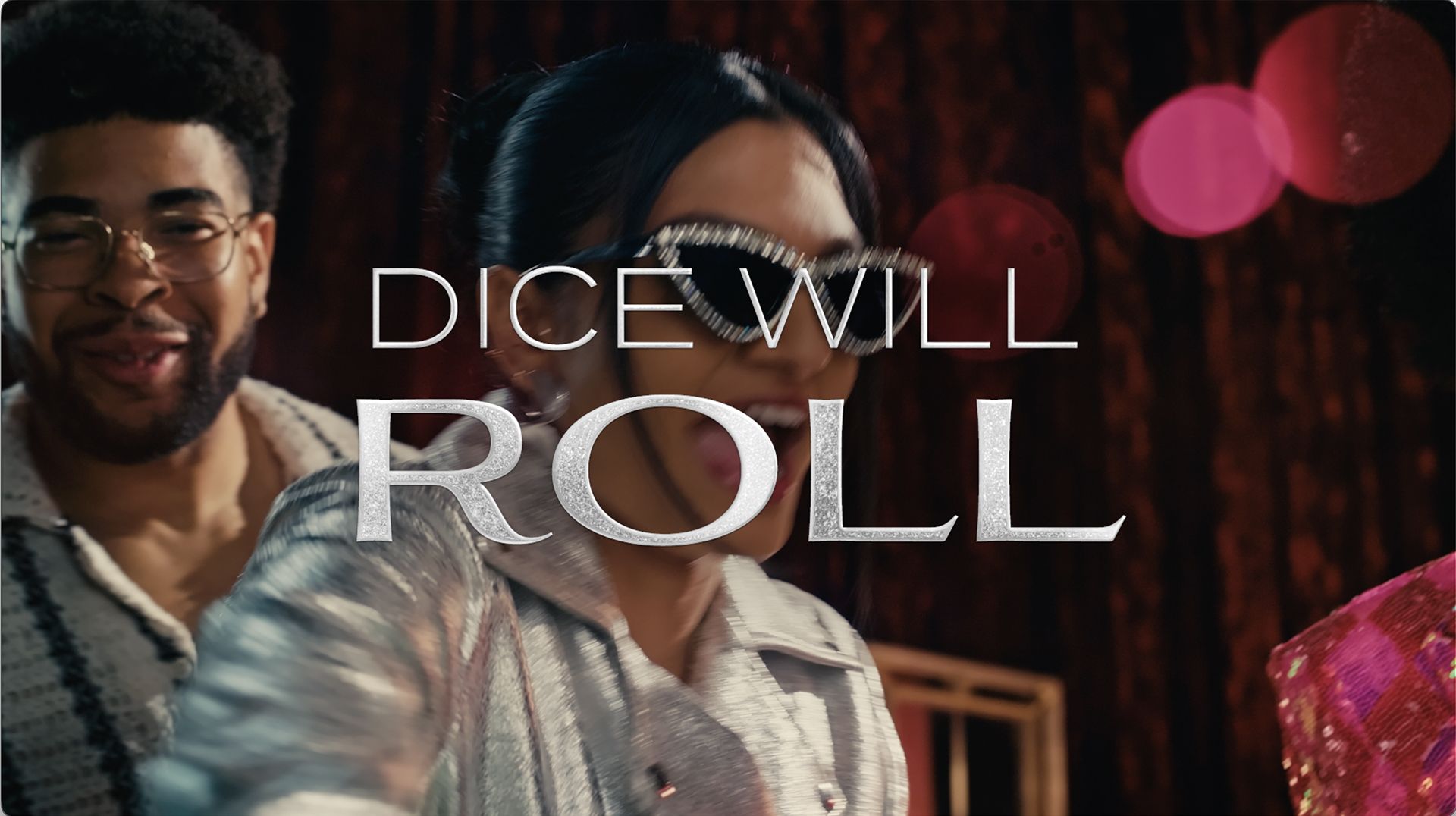 Man and woman smiling in front of a neon sign with the text 'DICE WILL ROLL'.